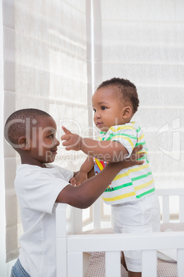 Babyboy playing with his brother in his bed