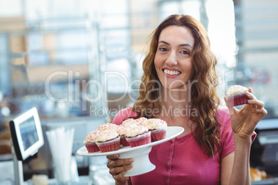 Pretty brunette showing cupcake