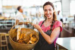 Pretty waitress carrying basket of bread