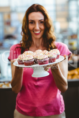 Pretty brunette holding plate of pastries