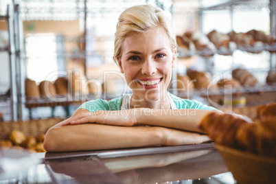 Smiling waitress posing next basket of bread