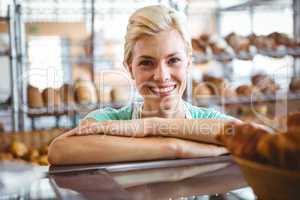 Smiling waitress posing next basket of bread