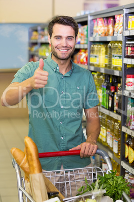 Portrait of smiling man buy products with his trollet and thumb