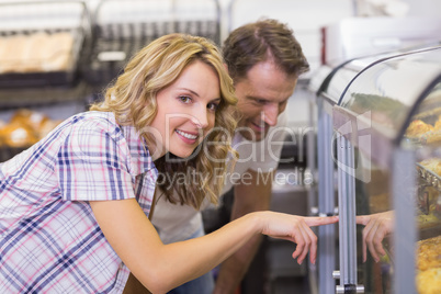 Portrait of a smiling casual couple showing a bread