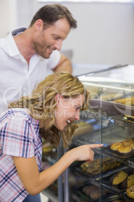 Smiling blonde woman looking at pastry