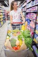 Smiling woman walking in aisle with his trollet