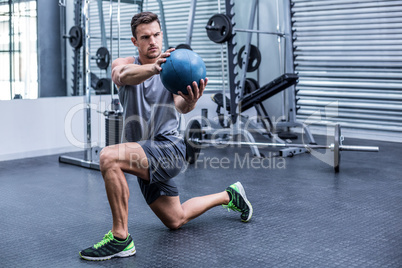Muscular man doing medecine ball exercises