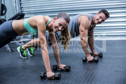 Muscular couple doing plank exercise together