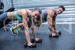 Muscular couple doing plank exercise together