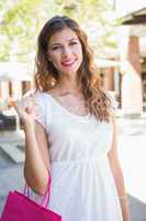 Portrait of smiling woman with shopping bags looking at camera