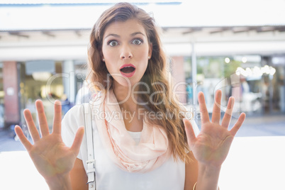 Portrait of astonished woman touching window with both hands