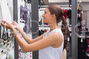 Young happy smiling woman looking at clothes
