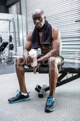 Young Bodybuilder holding a bottle of water after the training