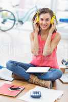 Young creative businesswoman listening to music