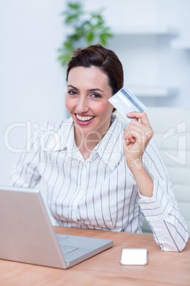 Pretty brunette businesswoman using her credit card