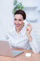 Pretty brunette businesswoman using her credit card