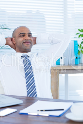 Relaxed businessman lying down in swivel chair