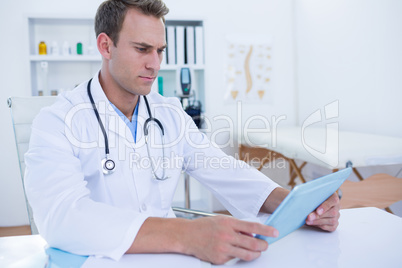 Focused doctor working with tablet computer