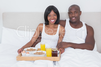 Portrait of a pretty couple taking breakfast in bed together