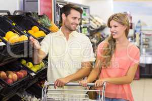 Smiling bright couple buying food products