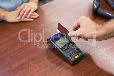 Woman at cash register paying with credit card