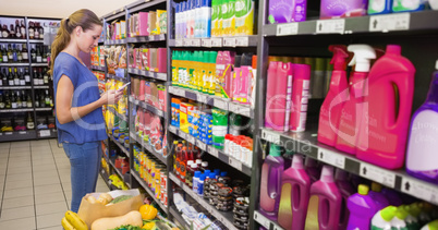 Woman texting in front of product shelf