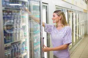 A pretty smiling blonde woman buying water