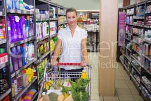Portrait of smiling woman walking in aisle with his trollet