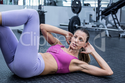 Muscular woman doing abdominal crunch