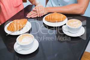 Coffee with hearts and bread with happy couple behind it