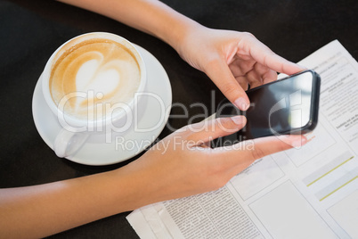 Coffee with a heart and hands holding a phone