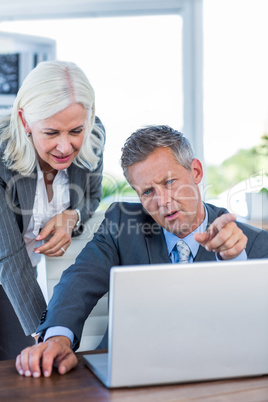 Serious business people working on laptop computer