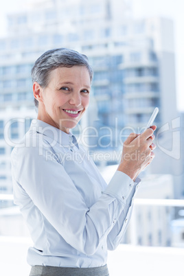 Businesswoman sending a text message in the office