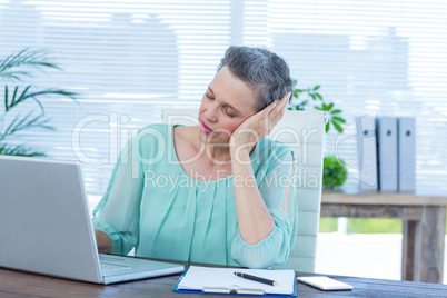 Tired businesswoman working on laptop