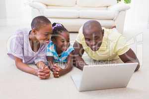 Happy smiling couple using laptop with their daughter