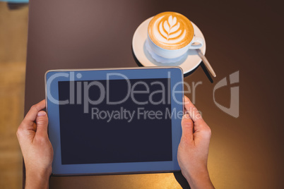 Close-up of digital tablet and coffee on table