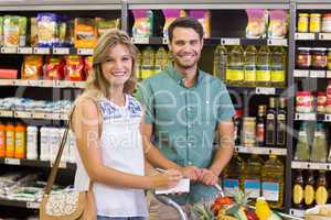 Portrait of smiling bright couple buying food products and uisng