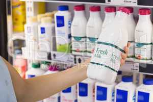 A woman having on her hands a fresh milk bottle