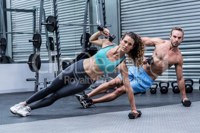 Muscular couple doing side plank