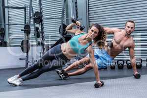 Muscular couple doing side plank