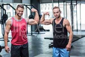 Two muscular men flexing biceps