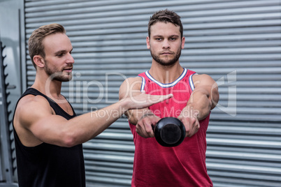 Muscular man lifting a kettle bell