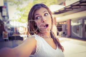 Astonished woman holding camera