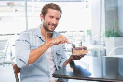 Young happy man eating his cake