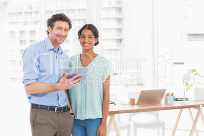 Casual business partners looking at tablet Casual business partners looking at tablet
