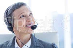 Smiling businesswoman phoning with headphone