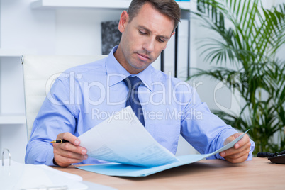 Businessman reading a contract before signing it