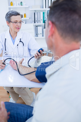 Doctor checking blood pressure of her patient