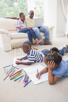 Happy siblings on the floor drawing