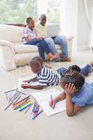 Happy siblings on the floor drawing